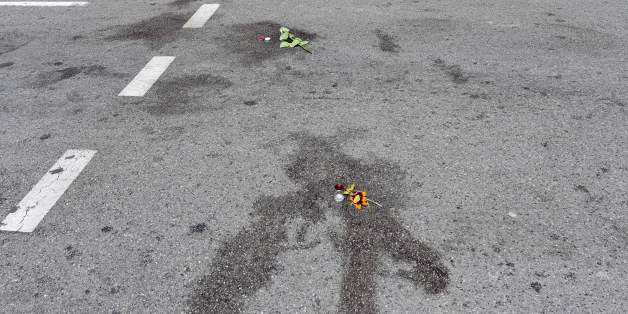 TOPSHOT - A picture taken on July 16, 2016 in Nice shows flowers placed on blood stains of victims of the deadly attack on the Promenade des Anglais seafront during Bastille Day.The Islamic State group claimed responsibility for the truck attack that killed 84 people in Nice on France's national holiday, a news service affiliated with the jihadists said Saturday. Tunisian Mohamed Lahouaiej-Bouhlel, 31, smashed a 19-tonne truck into a packed crowd of people in the Riviera city celebrating Bastill