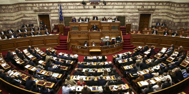Greece's Prime Minister Alexis Tsipras addresses lawmakers during a parliamentary session in Athens, on Sunday, May 8, 2016. Greek anarchists hurled firebombs, chairs and wooden planks at riot police in brief clashes outside parliament while lawmakers were debating a controversial austerity bill, disrupting a much larger peaceful rally on Sunday. (AP Photo/Yorgos Karahalis)