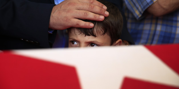Relatives mourn over the Turkish flag-draped coffin of their loved one, during a funeral for people killed Friday while protesting the attempted coup against Turkey's government, in Istanbul, Sunday, July 17, 2016. Rather than toppling Turkey's strongman president, a failed military coup appears to have bolstered Recep Tayyip Erdogan's immediate grip on power and boosted his popularity. (AP Photo/Lefteris Pitarakis)