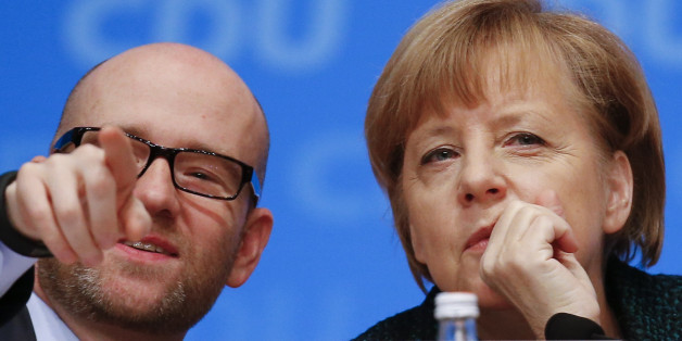 Christian Democratic Union (CDU) Secretary General Peter Tauber gestures next to German Chancellor Angela Merkel during the CDU party convention in Cologne December 9, 2014. German Chancellor Angela Merkel's conservative CDU party is holding its 27th party convention from December 8-10. REUTERS/Kai Pfaffenbach (GERMANY - Tags: POLITICS)