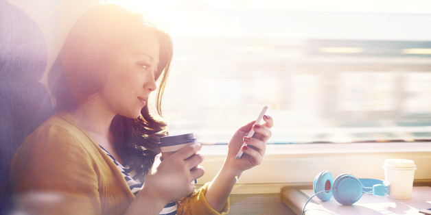Woman on a commuter train looking at her phone.
