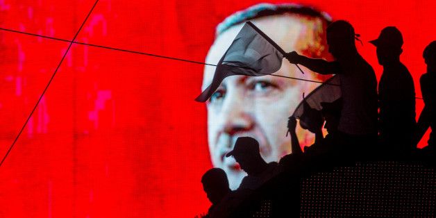 ANKARA, TURKEY - JULY 17: People wave Turkish flags in front of an electronic billboard displaying the face of President Recep Tayyip Erdogan at a rally on the streets of Kizilay Square in reaction to the failed military coup on July 17, 2016 in Ankara, Turkey. Clean up operations are continuing in the aftermath of Friday's failed military coup attempt which claimed the lives of more than 250 people. In raids across Turkey 6,000 people have been arrested in relation to the failed coup including high-ranking soldiers and judges, Turkey's Justice Minister Bekir Bozdag has said. (Photo by Chris McGrath/Getty Images)