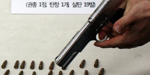 부산경찰청 마약수사대가 부산으로 잠입한 일본 조직폭력단(야쿠자) 조직원에게서 압수한 권총과 실탄. 경찰이 19일 방아쇠를 당겨 격발을 시연하고 있다.