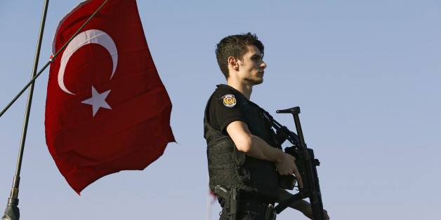 A policeman stands atop of a military armored vehicle after troops involved in the coup surrendered on the Bosphorus Bridge in Istanbul, Turkey July 16, 2016. REUTERS/Murad Sezer