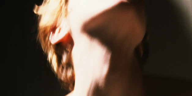 Hand pulling at woman's bra, close-up, blurred