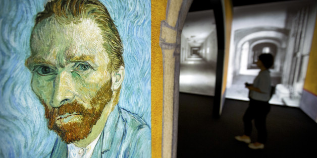 A visitor walks past an image of Van Gogh's "Self-Portrait" during a press event for the world premiere of the Meet Vincent Van Gogh exhibit in Beijing, China, Wednesday, June 15, 2016. The exhibit, created by curators at the Van Gogh Museum, draws on Van Gogh's personal mementoes and artwork to present the artist's life. It opens to the public on June 18. (AP Photo/Mark Schiefelbein)