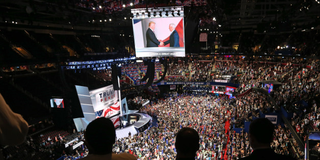 People watch a television monitor from the upper seats as U.S. Republican Presidential nominee Donald Trump (L) shakes hands with Indiana Governor and Vice Presidential Nominee Mike Pence on the third day of the Republican National Convention in Cleveland, Ohio, U.S. July 20, 2016. REUTERS/Aaron Josefczyk