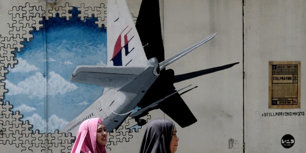 Malaysian women walk in front of a mural of missing Malaysia Airlines MH370 plane in a back-alley in Shah Alam on March 8, 2016. Malaysia and Australia said they remained 'hopeful' of solving the mystery of flight MH370 as the second anniversary of the plane's disappearance arrived March 8 with no end in sight for devastated families. / AFP / MANAN VATSYAYANA (Photo credit should read MANAN VATSYAYANA/AFP/Getty Images)