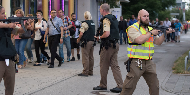 Police escort people who leave the Olympia mall in Munich, southern Germany, Friday, July 22, 2016 after shots were fired. Police said that at least six people have been killed. (AP Photo/Sebastian Widmann)