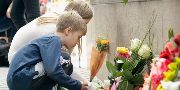 MUNICH, GERMANY - JULY 23: People lay flowers and candles outside the OEZ shopping center the day after a shooting spree left nine victims dead on July 23, 2016 in Munich, Germany. According to police an 18-year-old German man of Iranian descent shot nine people dead and wounded at least 16 before he shot himself in a nearby park. For hours during the spree and the following manhunt the city lay paralyzed as police ordered people to stay off the streets. Original reports of up to three attacker