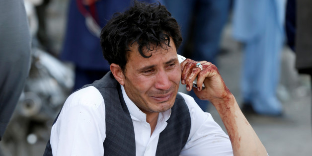 An Afghan man talks on his phone after a suicide attack in Kabul, Afghanistan July 23, 2016. REUTERS/Omar Sobhani TPX IMAGES OF THE DAY