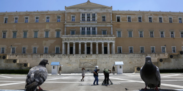 Pigeons perch on a police fence as a television crew films in front of the Greek parliament at an empty Syntagma (Constitution) square in central Athens during a visit by German Finance Minister Wolfgang Schaeuble July 18, 2013. Greek police have banned protests and traffic in downtown Athens on Thursday during a visit by Schaeuble, whom many accuse of forcing painful cuts on Greece in return for the multi-billion euro bailouts keeping it afloat. REUTERS/Yannis Behrakis (GREECE - Tags: POLITICS BUSINESS)