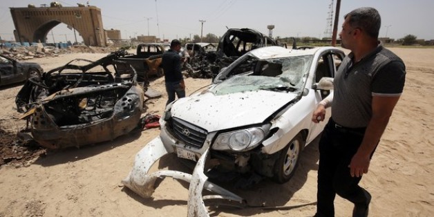 Des véhicules détruits lors d'un attentat suicide le 13 juillet 2016 à Bagdad