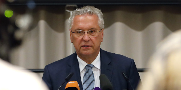 Bavarian Interior Minister Joachim Herrmann, center, briefs the media in Ansbach, Germany, Monday, July 25, 2016. Bavaria's top security official says a man who blew himself up after being turned away from an open-air music festival in the southern German city was a 27-year-old Syrian who had been denied asylum. (AP Photo/Matthias Schrader)