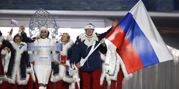 FILE - In this Feb. 7, 2014 file photo Alexander Zubkov of Russia carries the national flag as he leads the team during the opening ceremony of the 2014 Winter Olympics in Sochi, Russia. On Monday, July 18, 2016 a report on Russian doping by investigator Richard McLaren is to be released in Toronto. (AP Photo/Mark Humphrey, file)