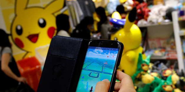 A man plays the augmented reality mobile game "Pokemon Go" by Nintendo in front of a shop selling Pokemon goods in Tokyo, Japan July 22, 2016. REUTERS/Toru Hanai TPX IMAGES OF THE DAY
