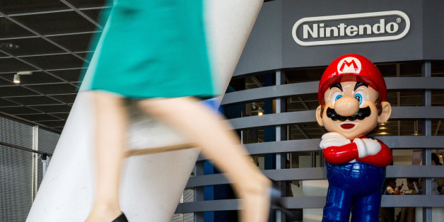 A woman walks past a figure of "Mario", a character in Nintendo's "Mario Bros." video games, at a Nintendo centre in Tokyo July 29, 2015. REUTERS/Thomas Peter/File Photo GLOBAL BUSINESS WEEK AHEAD PACKAGE - SEARCH "BUSINESS WEEK AHEAD JULY 25" FOR ALL IMAGES
