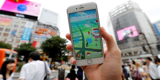 A man poses with his mobile phone displaying the augmented reality mobile game "Pokemon Go" by Nintendo in front of a busy crossing in Shibuya district in Tokyo, Japan, July 22, 2016. REUTERS/Toru Hanai/File Photo