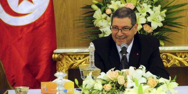 Tunisia's Prime Minister Habib Essid shares a smile with ministers prior to preside over an extraordinary Cabinet meeting in Carthage, outside Tunis, Saturday Jan. 23, 2016. Tunisia's prime minister, Habib Essid, cut short a visit to France as Tunisia's president vowed Friday to end the cycle of unrest that has pummeled towns across the country as authorities imposed a nationwide curfew, five years after the nation, convulsed by protests, overthrew its longtime ruler and moved onto the road to democracy. (AP Photo/Riadh Dridi)