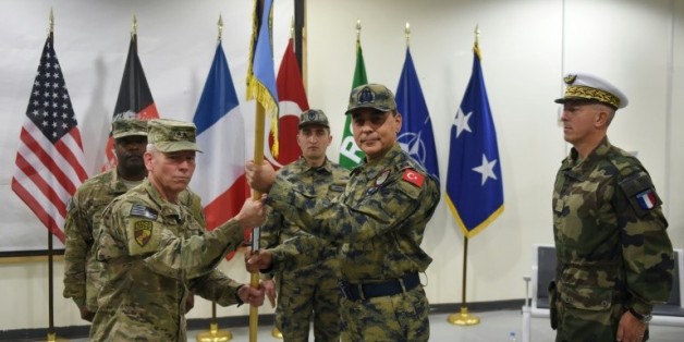 Le général turc Mehmet Cahit Bakir entre le commandant américain John McMullen et le général français Philippe Lavigne, lors d'une cérémonie de remise de drapeau le 31 décembre 2014 à Kaboul
