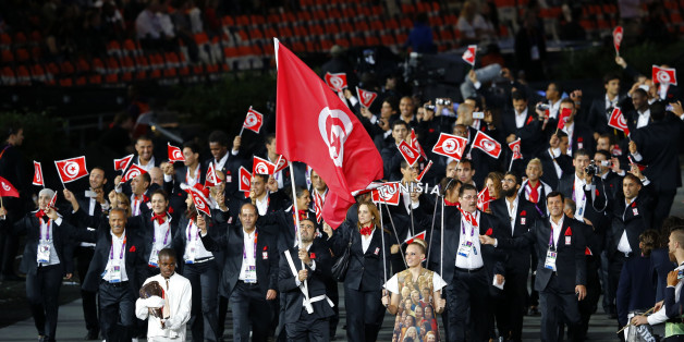 Tunisia's flag bearer Heykel Megannem holds the national flag as he leads the contingent in the athletes parade during the opening ceremony of the London 2012 Olympic Games at the Olympic Stadium July 27, 2012. REUTERS/Mike Blake (BRITAIN - Tags: SPORT OLYMPICS)