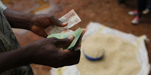 A Malawian trader counts money as he sells maize near the capital Lilongwe, Malawi February 1, 2016. Floods and an El Nino-triggered drought have hit the staple maize crop, exposing the fragility of Malawi's progress, which was partly rooted in a fertiliser grant for small-scale farmers that the government, now starved of donor funds, can ill afford. Picture taken February 1, 2016. To match Insight AFRICA-DROUGHT/MALAWI. REUTERS/Mike Hutchings