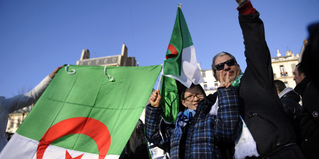 People hold Algerian flags on January 22, 2011 in Marseille, southern France, in support of local pro-democracy demonstrations in Algeria. The Algerian League for the Defence of Human Rights (LADDH) said today the blanket government ban on peaceful protest could cause a social explosion in the North African country, eight days after ousted leader Zine El Abidine Ben Ali fled Tunisia following violent street protests. AFP PHOTO / ANNE-CHRISTINE POUJOULAT (Photo credit should read ANNE-CHRISTINE P