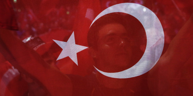 A man holds a Turkish flag during an anti coup rally at Taksim square in Istanbul, Tuesday, July 26, 2016. Turkey's polarized factions should learn from their mistakes and overcome their antagonism, the main opposition leader Kemal Kilicdaroglu said during an interview with The Associated Press. (AP Photo/Petros Karadjias)