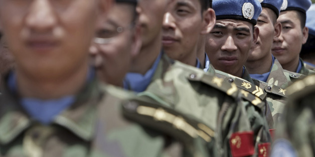 Newly arrived engineers from China serving with the United Nations-African Union Mission in Darfur (UNAMID) stand to attention after arriving in Nyala, South Darfur in this handout picture July 17, 2008. REUTERS/Albany Associates/Stuart Price/Handout (SUDAN). FOR EDITORIAL USE ONLY. NOT FOR SALE FOR MARKETING OR ADVERTISING CAMPAIGNS.