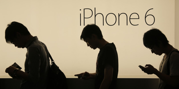 FILE - In this Friday, Sept. 19, 2014, file photo, people wait to buy the new Apple iPhone 6 and 6 Plus devices outside an Apple store in Hong Kong. Apple is embroiled in a Chinese patent dispute that threatens to block future sales of the iPhone 6 in Beijing unless the company can overturn a regulator's recent ruling. The potential ban stems from a decision issued in May 2016 by the Beijing Intellectual Property Office. The agency found the iPhone 6 and iPhone 6 Plus infringed on a Chinese comp