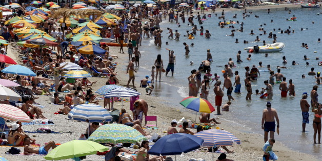 People enjoy the sunny weather on the beach of Alimos, south of Athens, Greece, July 12, 2015. Euro zone leaders will fight to the finish to keep near-bankrupt Greece in the single currency on Sunday after the European Union's chairman canceled a planned summit of all 28 EU leaders that would have been needed in case of a "Grexit". REUTERS/Jean-Paul Pelissier