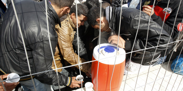 People fleeing the unrest in Tunisia drink water after they arrive at the southern Italian island of Lampedusa March 15, 2011. Thousands of immigrants have arrived by boat in Lampedusa from Tunisia over the past few weeks in the wake of the uprising that toppled long-time ruler Zine al-Abidine Ben Ali, prompting Italian government ministers to warn that the unrest in North Africa could trigger an exodus "of biblical proportions". REUTERS/Stefano Rellandini (ITALY - Tags: CIVIL UNREST SOCIETY)