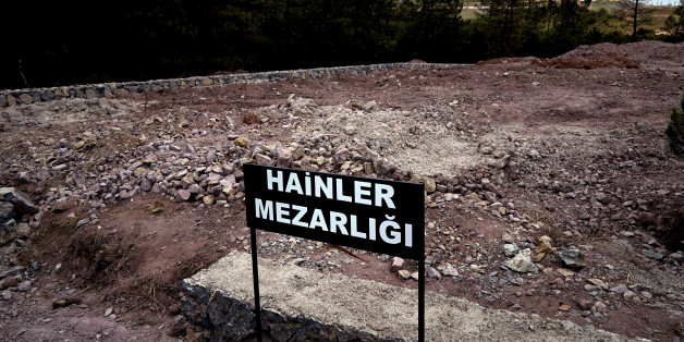 CORRECTS PHOTOGRAPHER'S NAME - A sign reading in Turkish "Traitors' Cemetery" is seen in front of unmarked graves, built specifically to hold the bodies of coup plotters who died in the failed military coup of July 15, in eastern Istanbul Wednesday, July 27, 2016. In the week following the attempted coup, the local municipality announced it intended to set up a cemetery specifically for those involved - traitors who didn't deserve a decent burial. (AP Photo/Bram Janssen)