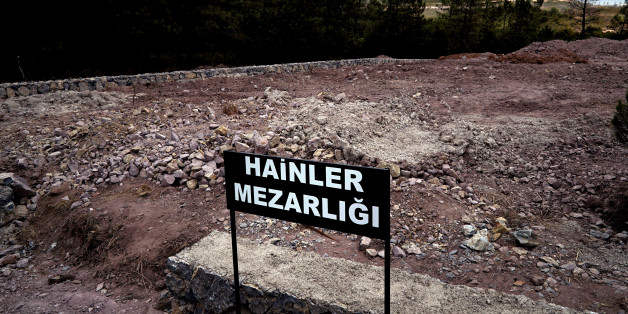 CORRECTS PHOTOGRAPHER'S NAME - A sign reading in Turkish "Traitors' Cemetery" is seen in front of unmarked graves, built specifically to hold the bodies of coup plotters who died in the failed military coup of July 15, in eastern Istanbul Wednesday, July 27, 2016. In the week following the attempted coup, the local municipality announced it intended to set up a cemetery specifically for those involved - traitors who didn't deserve a decent burial. (AP Photo/Bram Janssen)