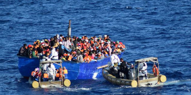 Migrants sit in their boat during a rescue operation by Italian navy ship Borsini (unseen) off the coast of Sicily, Italy, in this handout picture courtesy of the Italian Marina Militare released on July 19, 2016. Marina Militare/Handout via REUTERS ATTENTION EDITORS - THIS PICTURE WAS PROVIDED BY A THIRD PARTY. FOR EDITORIAL USE ONLY.