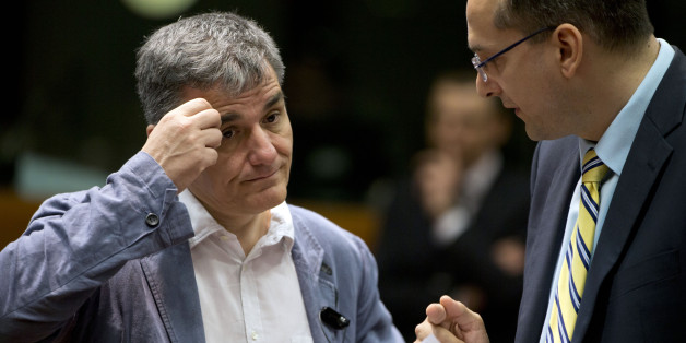 Greece's Finance Minister Eucleidis Tsakalotos, left, speaks with a member of his delegation during a meeting of EU finance ministers in Brussels on Wednesday, May 25, 2016. Eurozone finance ministers struck a deal early Wednesday clearing the way for Greece to access a fresh round of bailout funds, while also laying out debt relief measures aimed at securing the involvement of the International Monetary Fund, or IMF. (AP Photo/Virginia Mayo)