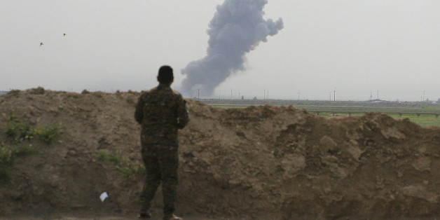 Smoke rises from positions in the Islamic State group held town of Besher, during a military operation to regain control of the small town, outside the oil-rich city of Kirkuk, 180 miles (290 kilometers) north of Baghdad, Iraq, Sunday, April 10, 2016. (AP Photo/Anmar Khalil)