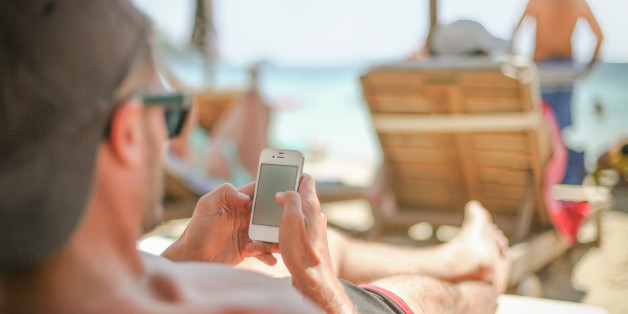 Man using smart phone at sea