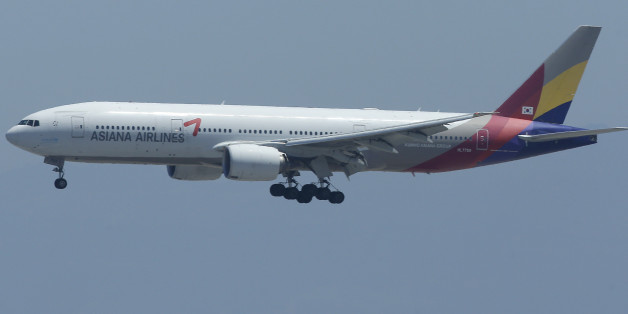FILE - In this Tuesday, July 9, 2013 file photo, Asiana Flight 214 comes in for a landing over the wreckage of Saturday's crashed Asiana Flight 214 at San Francisco International Airport in San Francisco. Asiana Airlines Inc., operator of the jet that crash landed in San Francisco last month, reported a second straight quarterly loss as North Korean war threats and a bird flu scare dented travel. (AP Photo/Jeff Chiu, File)