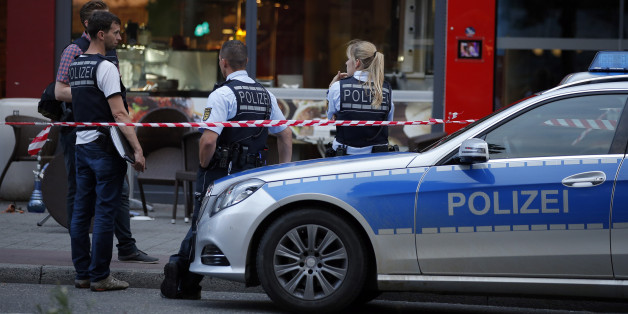 Police stand outside where a 21-year-old Syrian refugee killed a woman with a machete and injured two other people in the city of Reutlingen, Germany July 24, 2016. REUTERS/Vincent Kessler