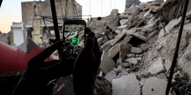 A Syrian gamer uses the Pokemon Go application on his mobile to catch a Pokemon amidst the rubble in the besieged rebel-controlled town of Douma, a flashpoint east of the capital Damascus on July 23, 2016. / AFP / Sameer Al-Doumy (Photo credit should read SAMEER AL-DOUMY/AFP/Getty Images)