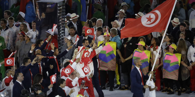 Oussama Mellouli carries the flag of Tunisia during the opening ceremony for the 2016 Summer Olympics in Rio de Janeiro, Brazil, Friday, Aug. 5, 2016. (AP Photo/Markus Schreiber)