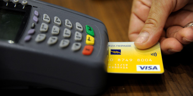 A sales staff accepts payment by credit card through a point-of-sale (POS) device at a boutique shop in central Athens, Greece, May 10, 2016. Picture taken May 10, 2016. REUTERS/Michalis Karagiannis