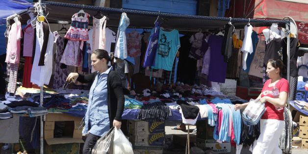 Women walks past a clothing stall during the holy month of Ramadan in the old city of Tunis August 10, 2012. REUTERS/Zoubeir Souissi (TUNISIA - Tags: RELIGION SOCIETY)
