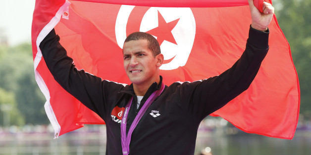 Tunisia's Oussama Mellouli poses with his gold medal wrapped in national flag after the men's 10km marathon swimming at Hyde Park during the London Olympic Games August 10, 2012. REUTERS/Dominic Ebenbichler (BRITAIN - Tags: OLYMPICS SPORT SWIMMING)