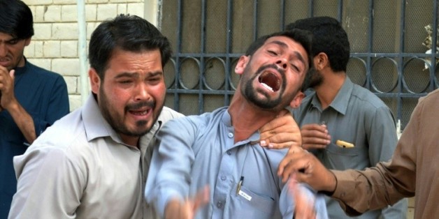 Des Pakistanais sur le site de l'explosion revendiquée par les talibans et l'EI