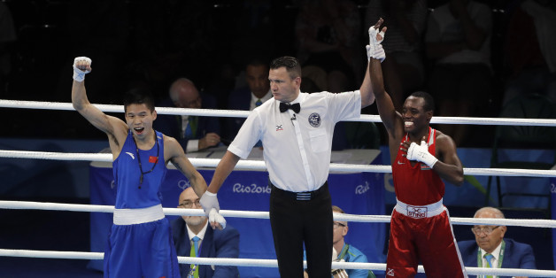 The referee looks at China's Bin LV, left, as he lifts the hand of Kenya's Peter Mungai Warui after a men's light flyweight 49-kg preliminary boxing match at the 2016 Summer Olympics in Rio de Janeiro, Brazil, Monday, Aug. 8, 2016. (AP Photo/Jae C. Hong)