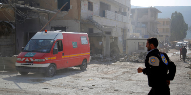 A civil defence member runs near an ambulance after an airstrike on a hospital in the town of Meles, western Idlib city in rebel-held Idlib province, Syria August 6, 2016. REUTERS/Ammar Abdullah