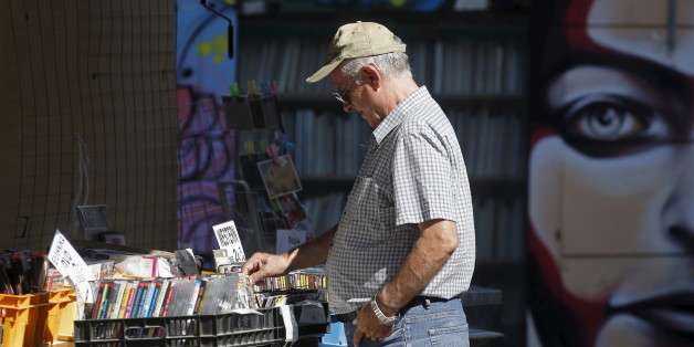 A man looks at used DVDs at a store at Monastiraki area in central Athens, Greece, July 7, 2015. Greece faces a last chance to stay in the euro zone on Tuesday when Prime Minister Alexis Tsipras puts proposals to an emergency euro zone summit after Greek voters resoundingly rejected the austerity terms of a defunct bailout. REUTERS/Christian Hartmann
