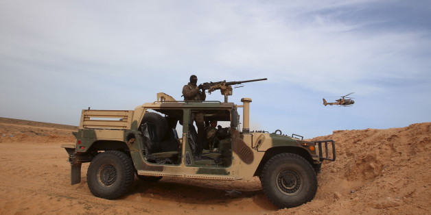 A Tunisian soldier holds his position during an exercise along the frontier with Libya in Sabkeht Alyun, Tunisia February 6, 2016. Tunisia has completed a 200-km (125 mile) barrier along its frontier with Libya to try to keep out Islamist militants, and will soon install electronic monitoring systems, Defence Minister Farhat Hachani said on Saturday. REUTERS/Zoubeir Souissi TPX IMAGES OF THE DAY